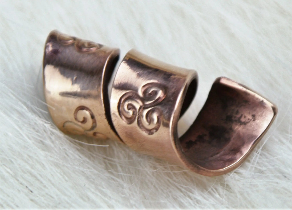 The hole is around 10 mm diameter leaving plenty of space for a thick beard or dreadlocks.